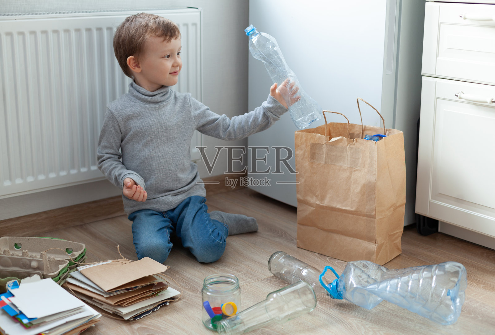 那个男孩在厨房里把垃圾分类。分类纸张、塑料、玻璃。零浪费的概念。3R理念:减少、再利用、回收照片摄影图片