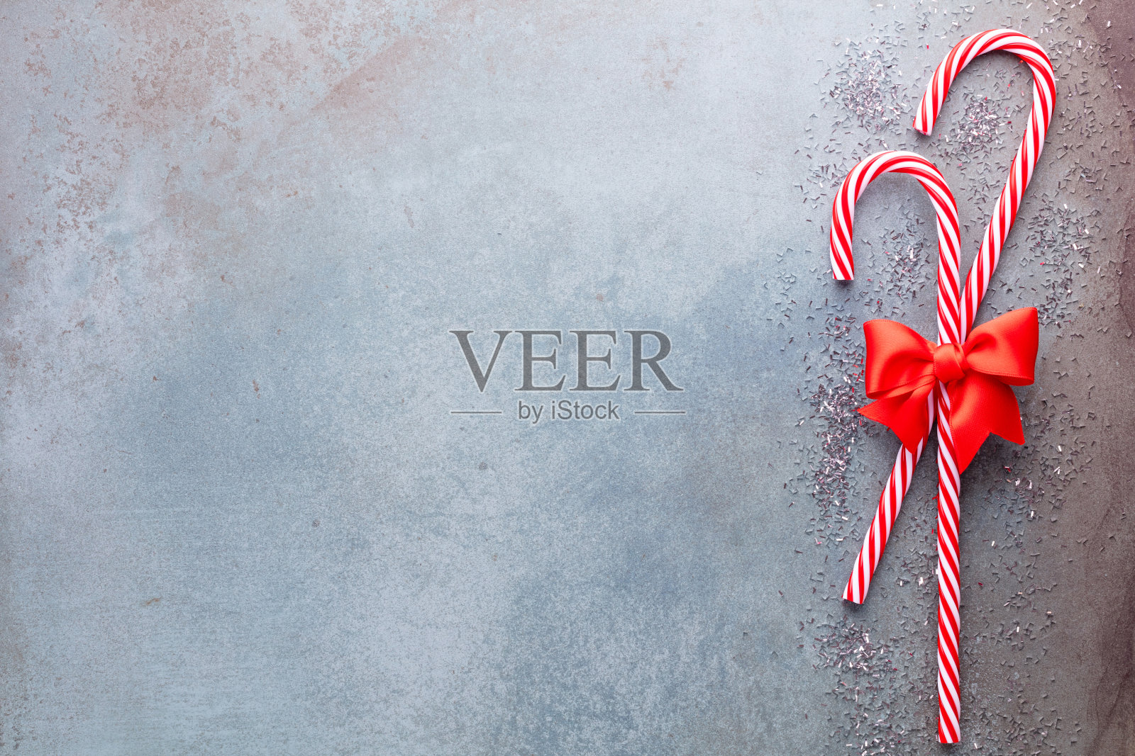 圣诞拐杖糖躺在蓝色的背景上。平躺和顶视图。照片摄影图片