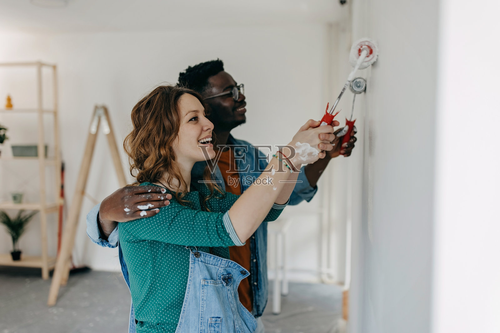 年轻夫妇粉刷墙壁照片摄影图片