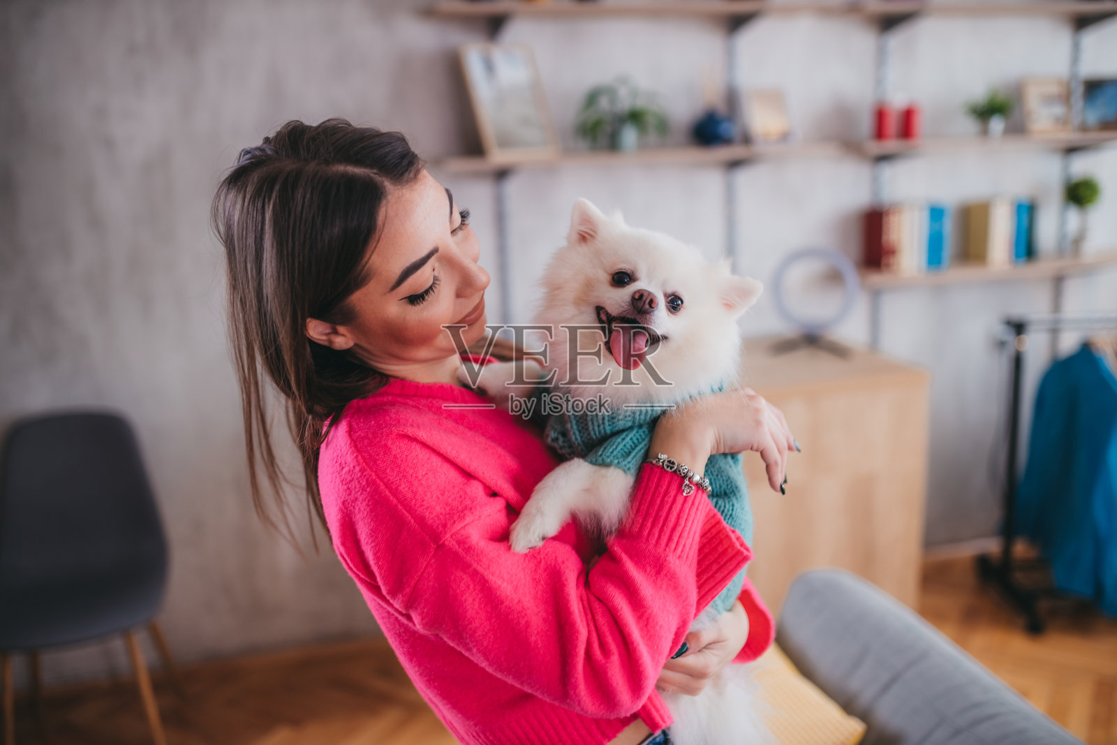 一个快乐的女人把她的狗斯皮兹抱在怀里照片摄影图片