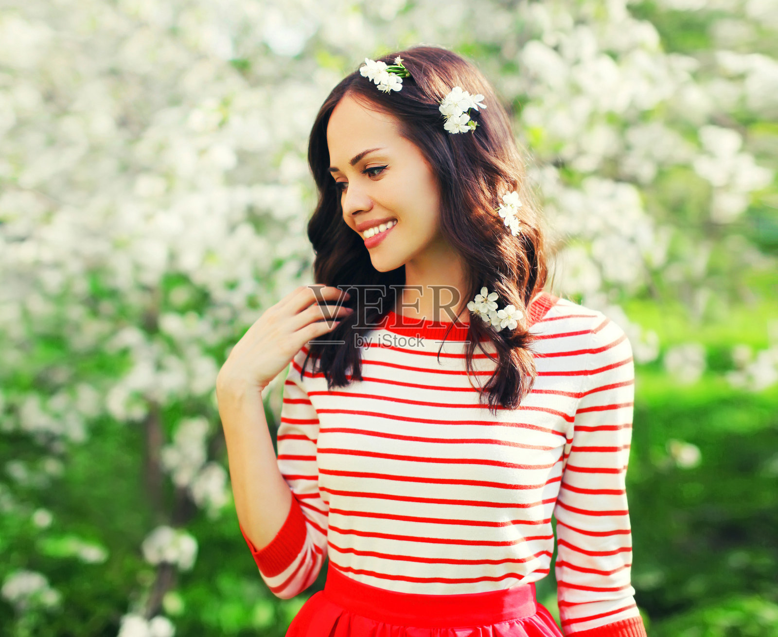 美丽可爱的年轻女子的肖像在春天盛开的花园白花的背景照片摄影图片