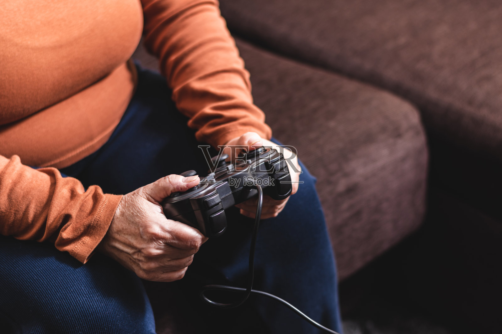 一个不认识的女人在玩游戏机。成熟的白人女人在玩游戏机。照片摄影图片