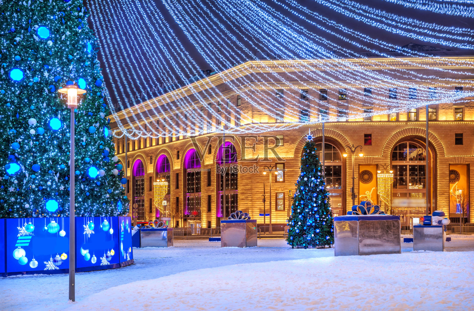 在夜晚的灯光下，莫斯科中央儿童世界大楼附近的卢比扬卡广场上的一棵圣诞树照片摄影图片