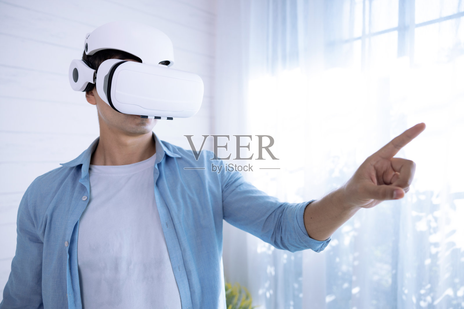 白人男子戴着虚拟现实眼镜，表现得好像他从眼镜里看到了什么，虚拟现实眼镜，超时空，虚拟现实，现代技术。照片摄影图片