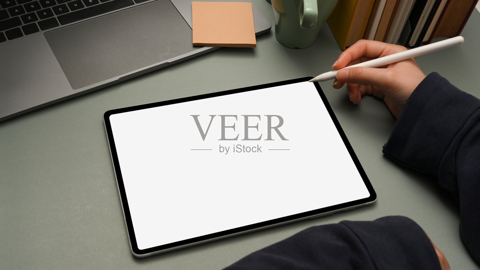 近景，现代办公桌与女性使用手写笔在平板上素描。照片摄影图片