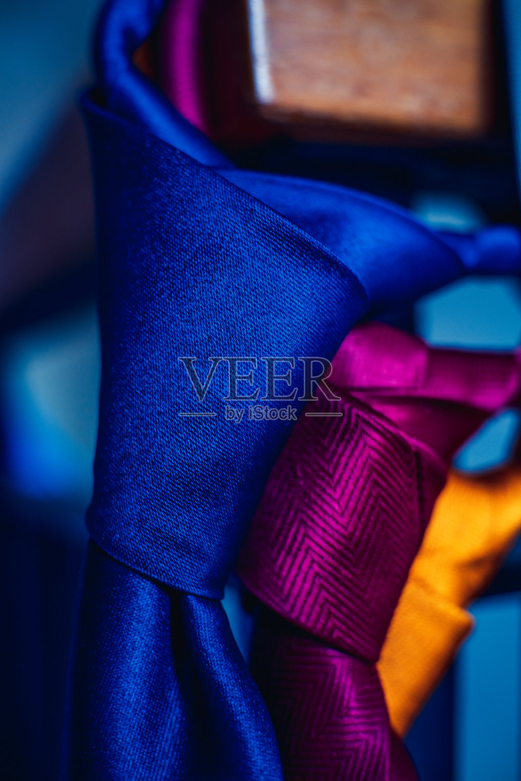 五颜六色的领带挂在把手的末端，随时可以佩戴。照片摄影图片