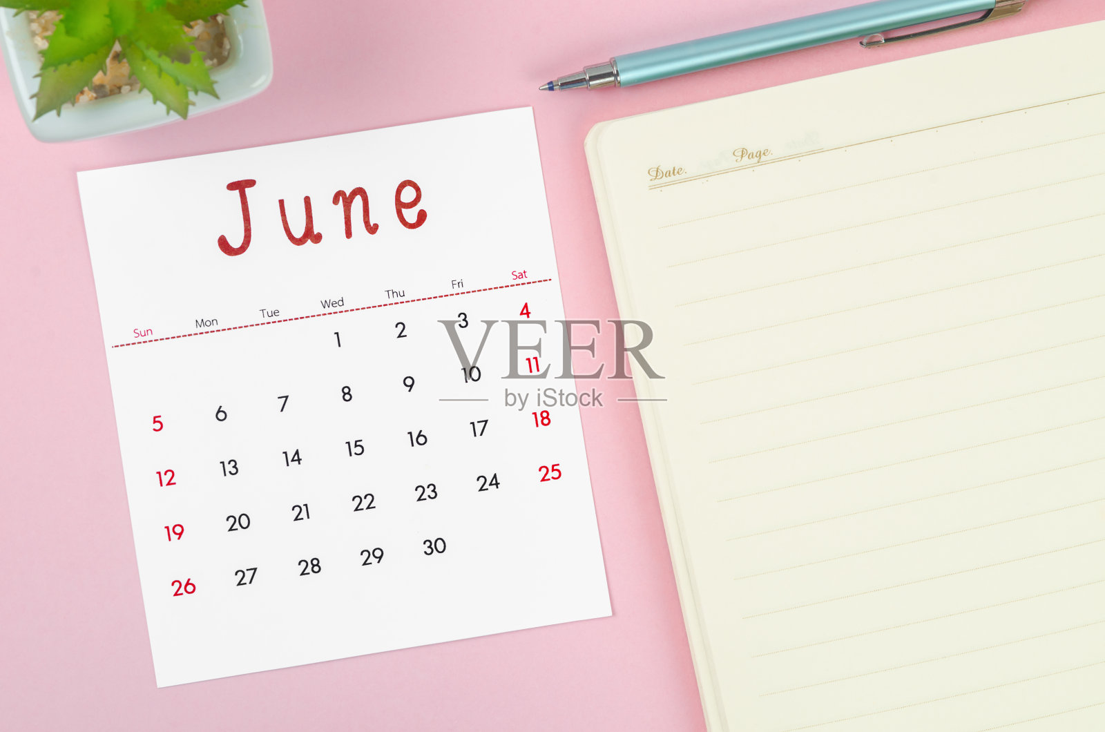 2022年6月日历，粉红色背景的笔记本。照片摄影图片