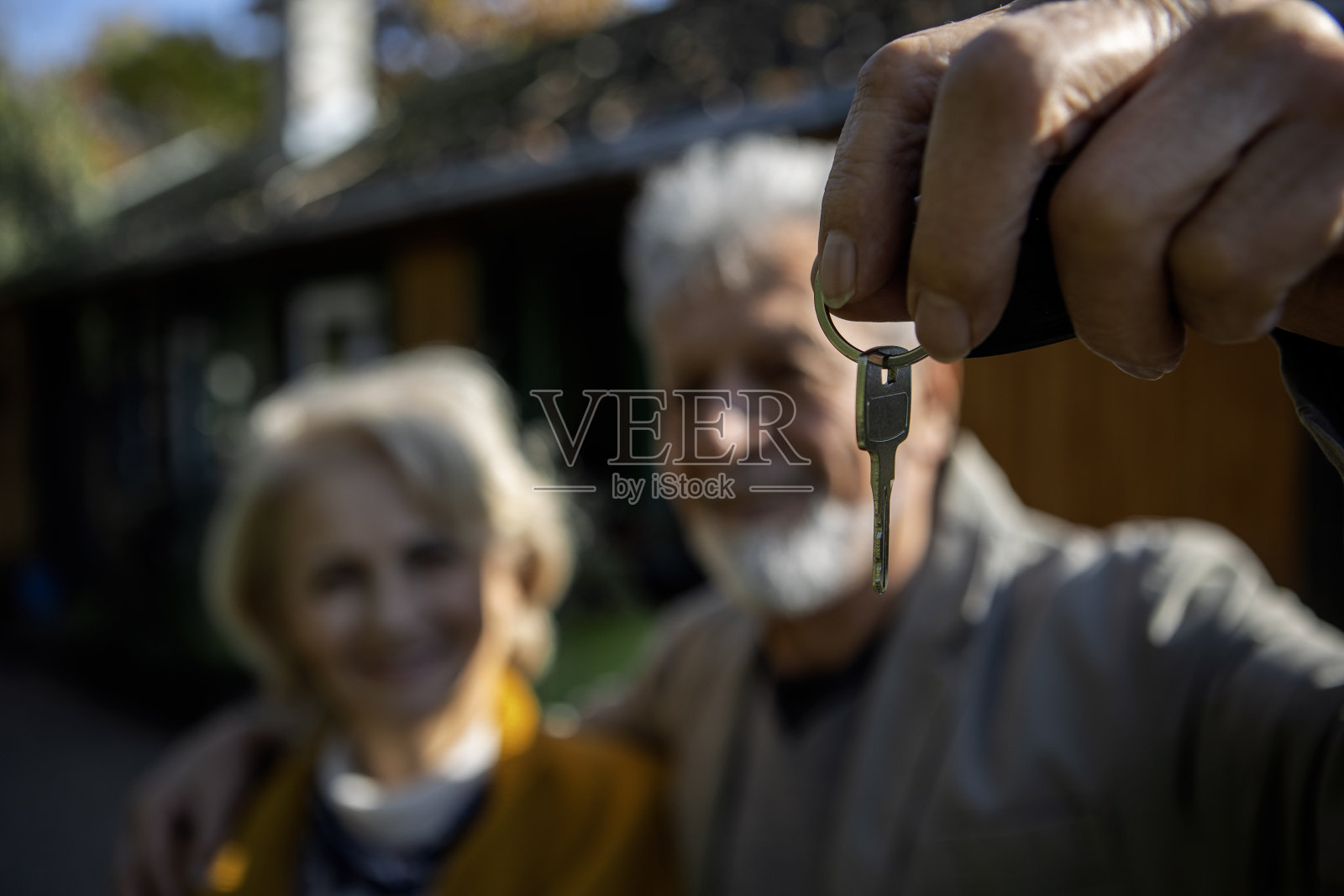 一对老夫妇拿着房子的钥匙照片摄影图片