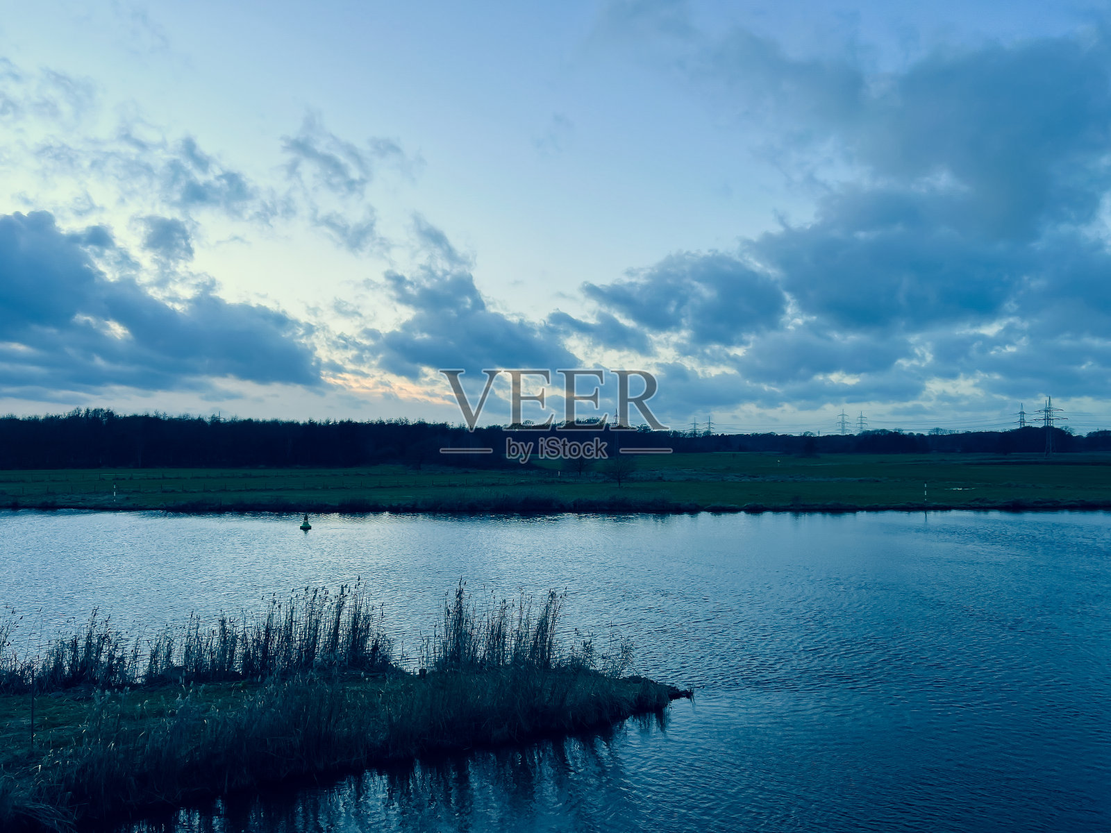 这条河名叫“Ems”，在冬天的傍晚，它靠近一片田野和一片森林。照片摄影图片