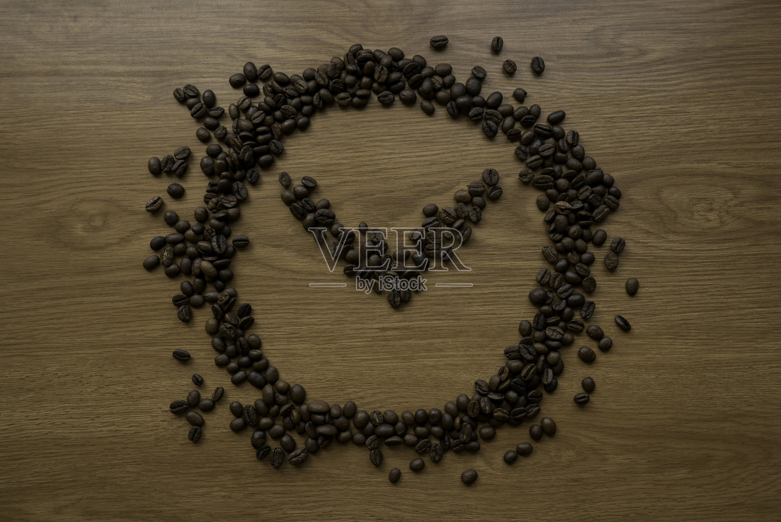 时钟形状的烤咖啡豆。喝咖啡的时间概念。照片摄影图片