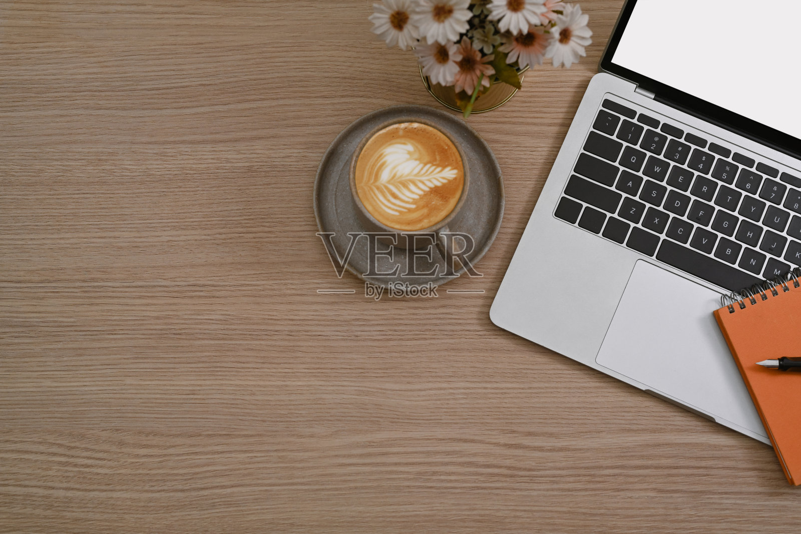 俯视图咖啡杯，笔记本电脑，笔记本和花盆在木桌上。照片摄影图片