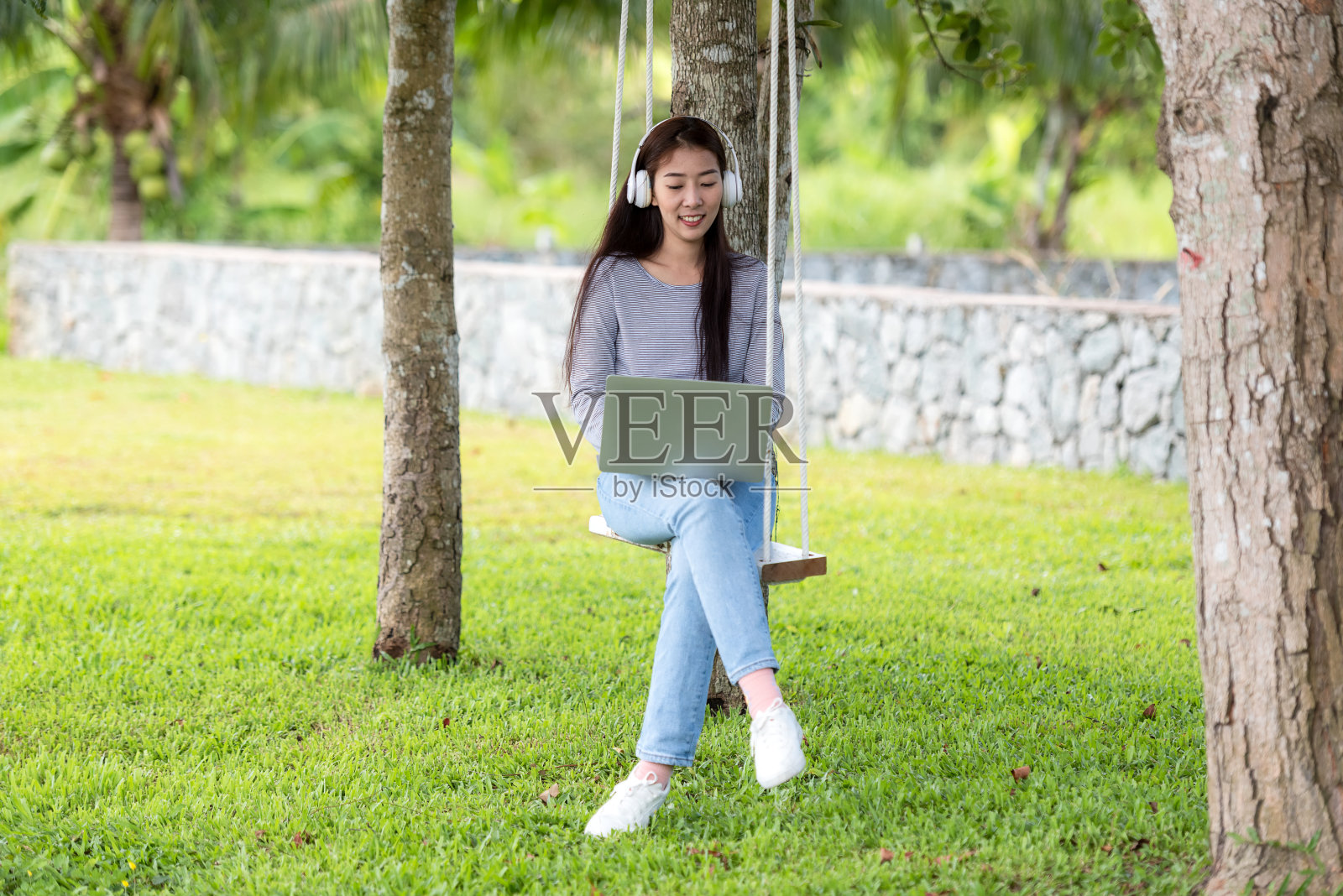 生活方式人们女孩工作教育笔记本电脑和听音乐放松户外花园在家里。照片摄影图片