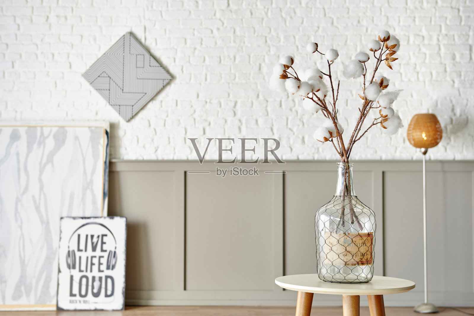 棉花花在玻璃花瓶的桌子上，现代装饰墙的房间背景风格。照片摄影图片