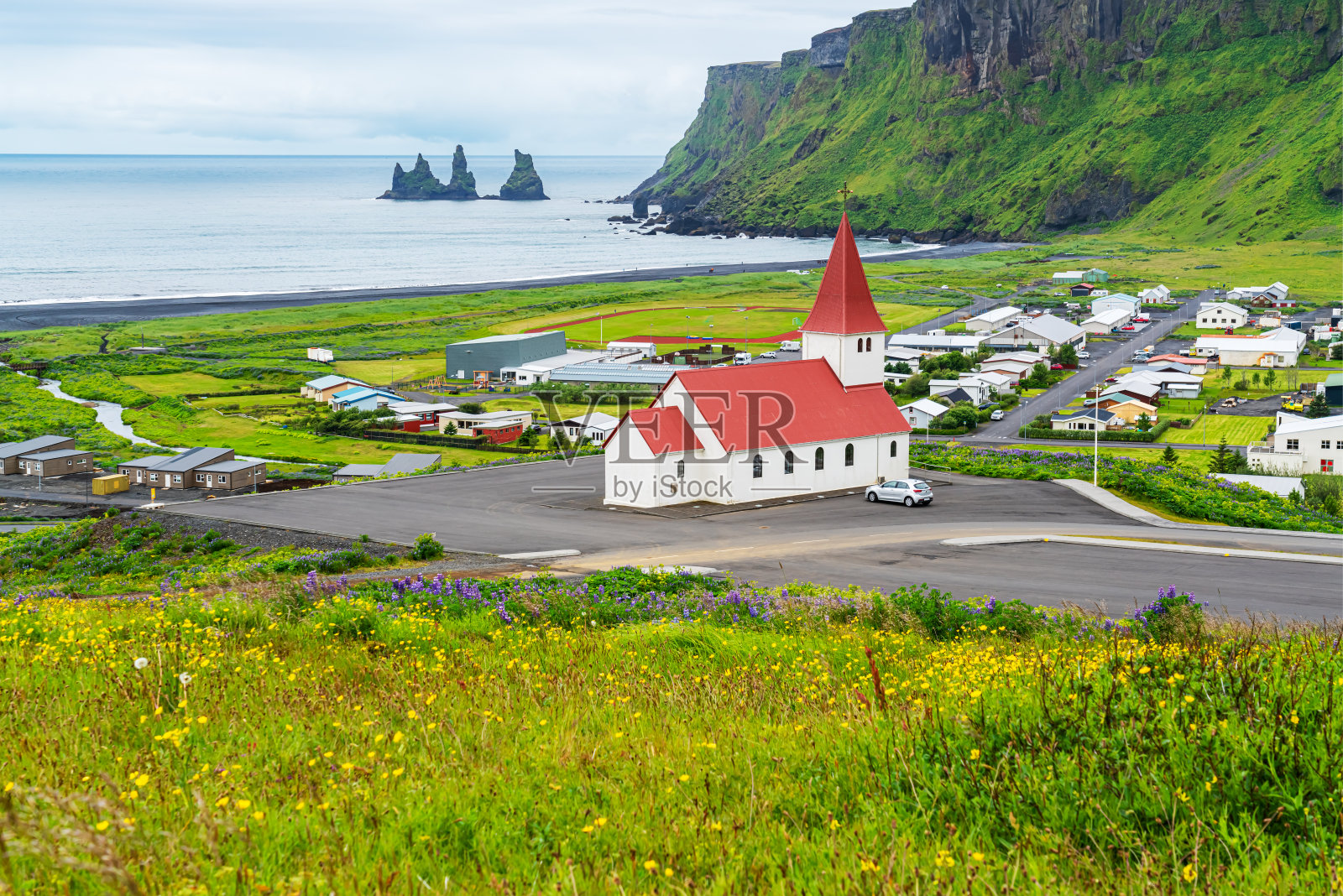 美丽的维克和山上的Reyniskirkja教堂。照片摄影图片