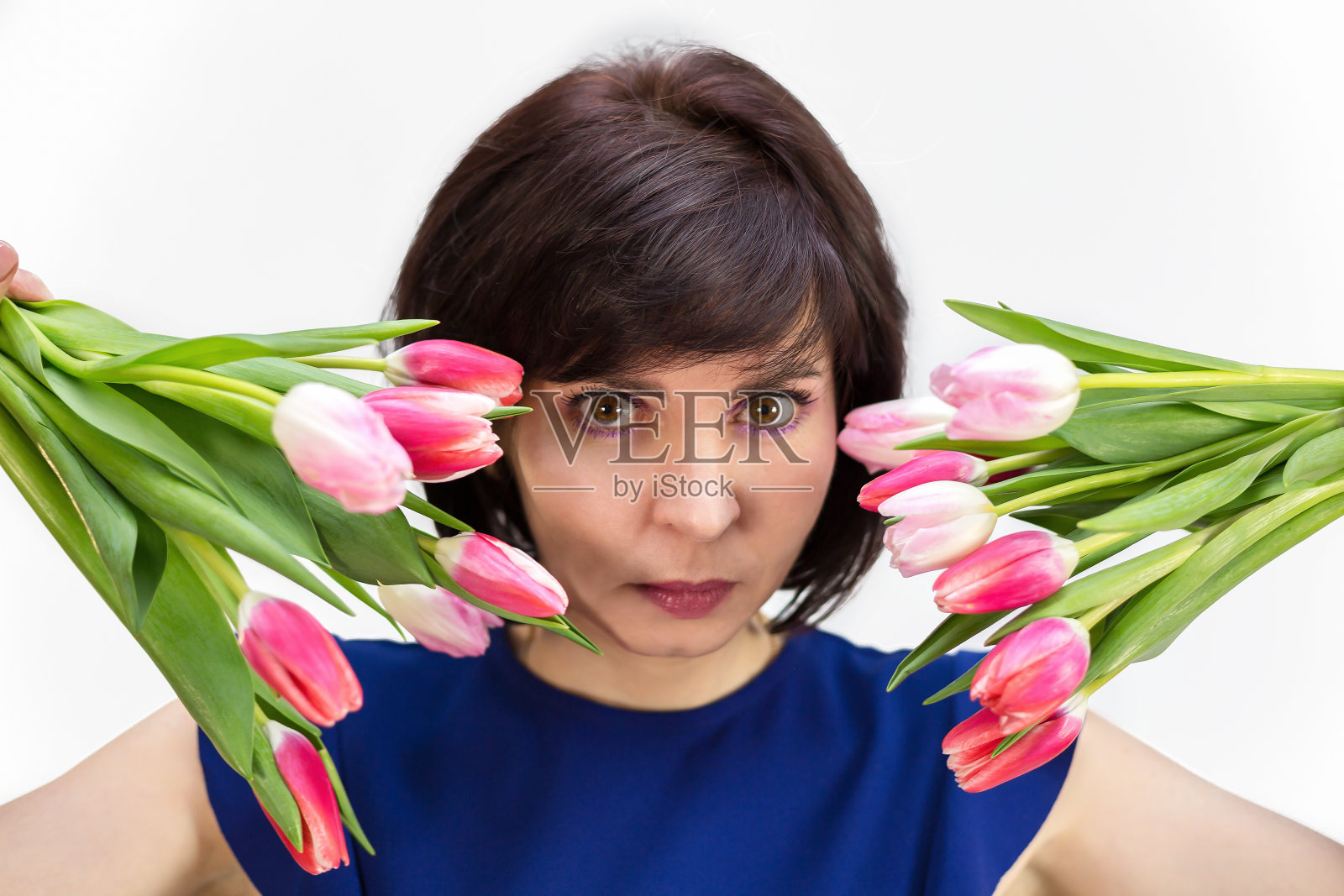 一个有着美丽微笑的黑发女人的肖像与一束明亮新鲜的郁金香，孤立的，白色的背景照片摄影图片