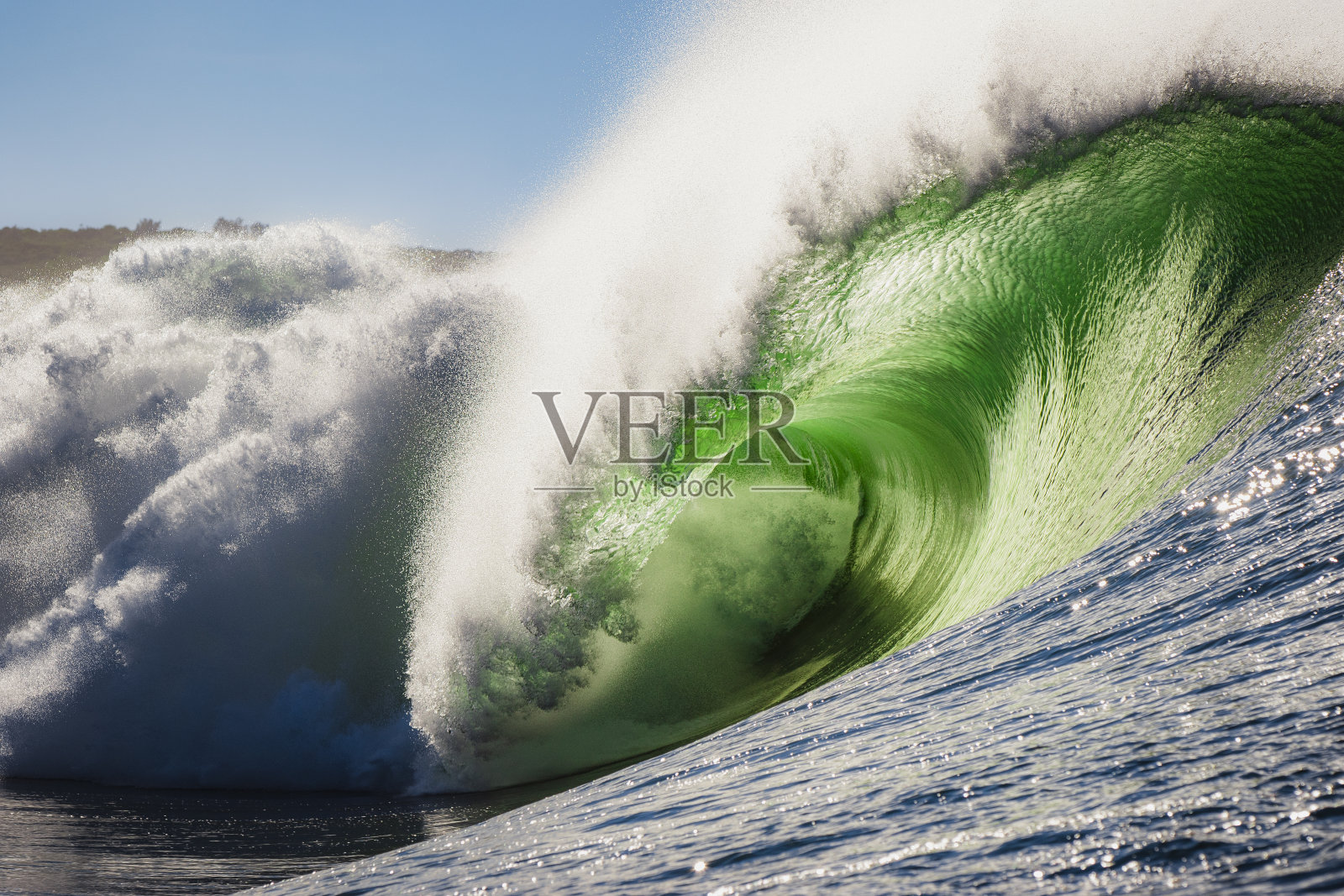 完美的海浪撞击礁石，明亮的绿色和温暖的环境照片摄影图片