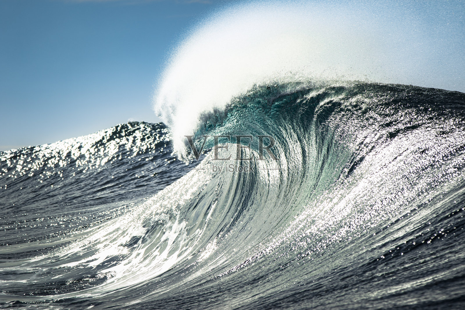 蓝绿色的波浪在开阔的海洋中打破了热明亮的光照片摄影图片