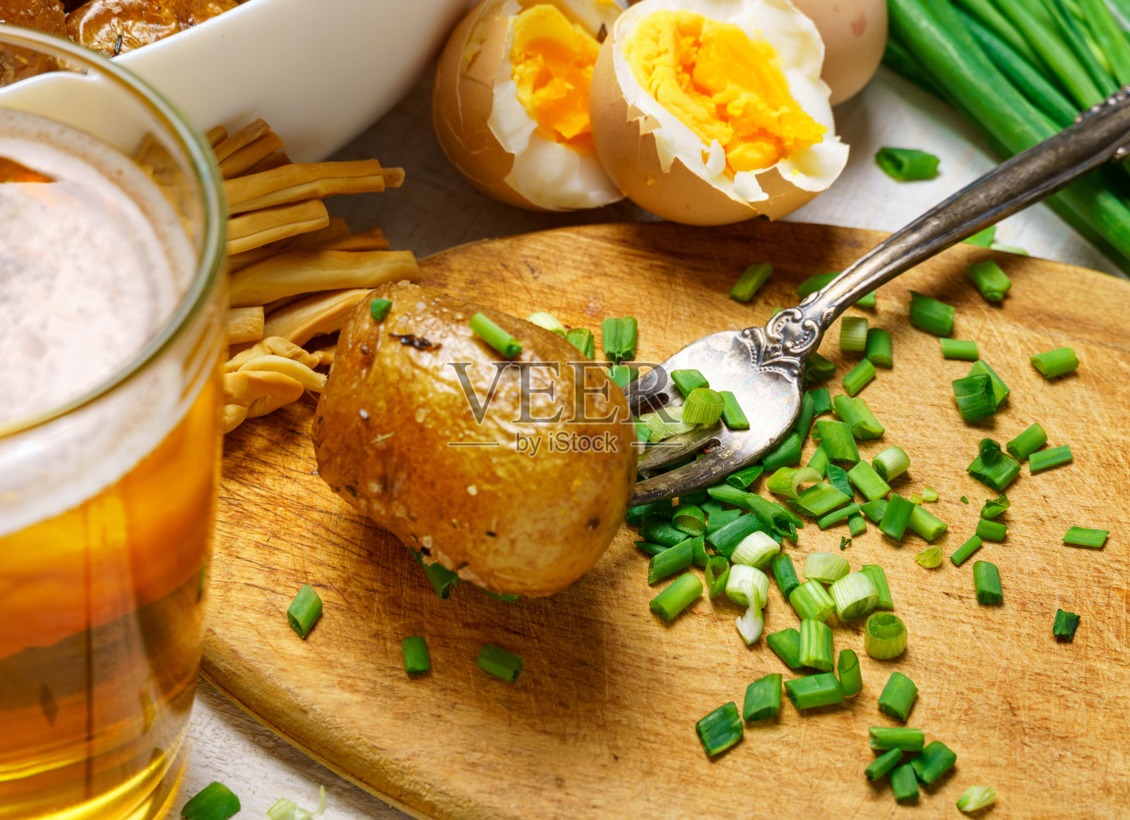 乡村风味的美味午餐，健康的食物-一杯啤酒，炸鸡和土豆，大蒜和大葱，奶酪，煮鸡蛋和盐，熟食照片摄影图片