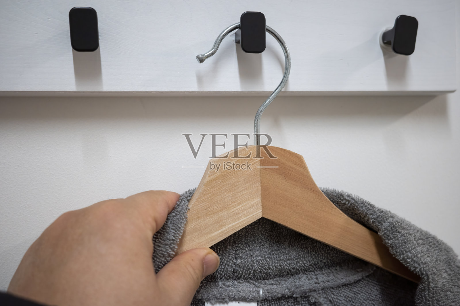 这个人正在把衣服挂在架子上照片摄影图片