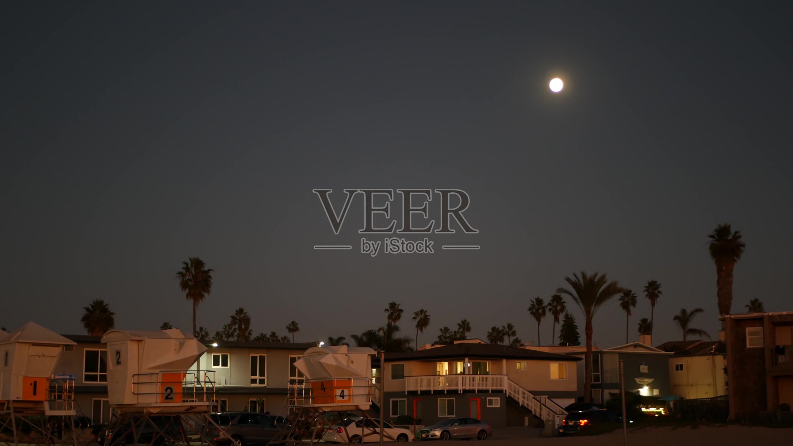 棕榈树和黄昏天空中的月亮，加州海岸救生员，海滩别墅。照片摄影图片