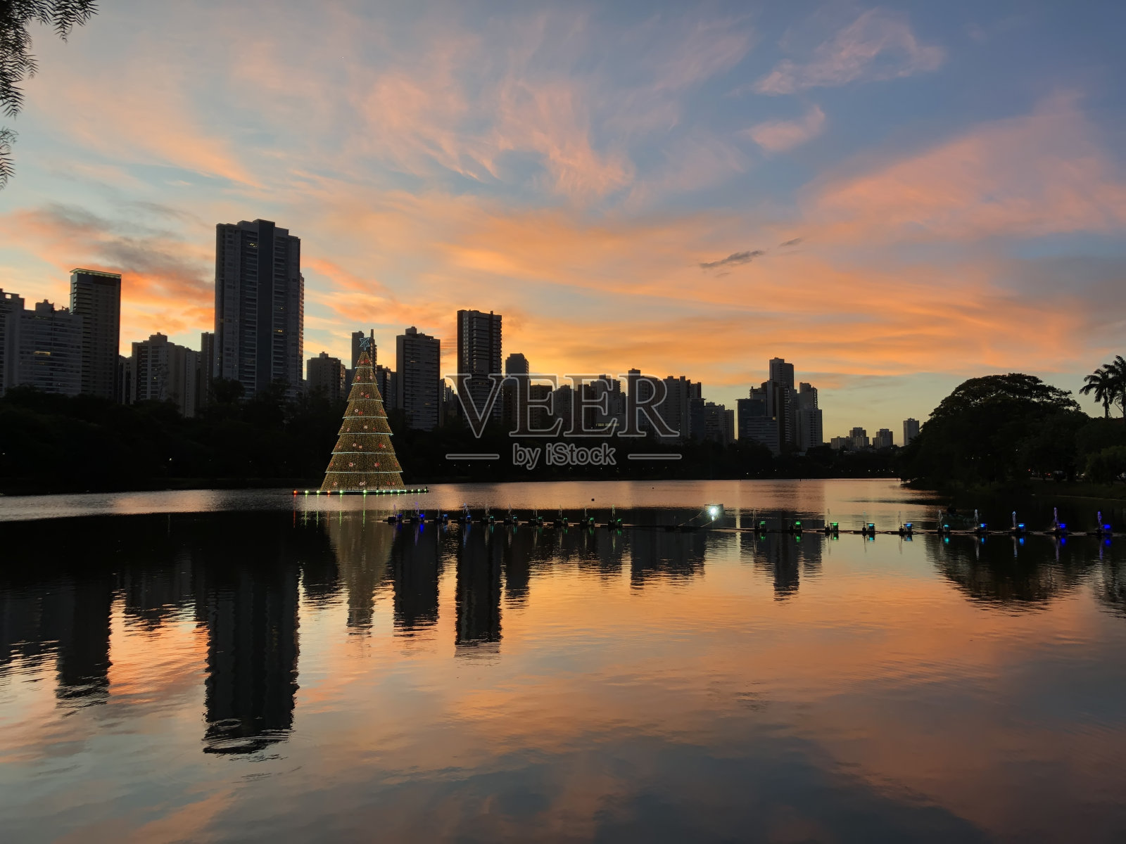 湖上挂着彩灯的圣诞树。照片摄影图片