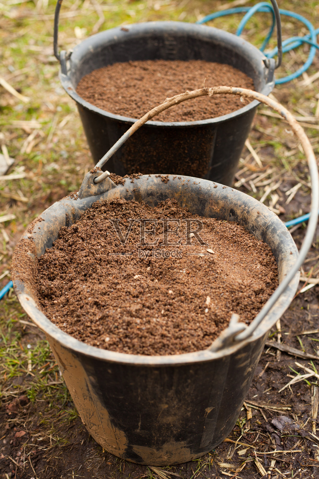 用草泥建造房屋-在建筑工地搅拌原料。传统建筑的古老技术。照片摄影图片