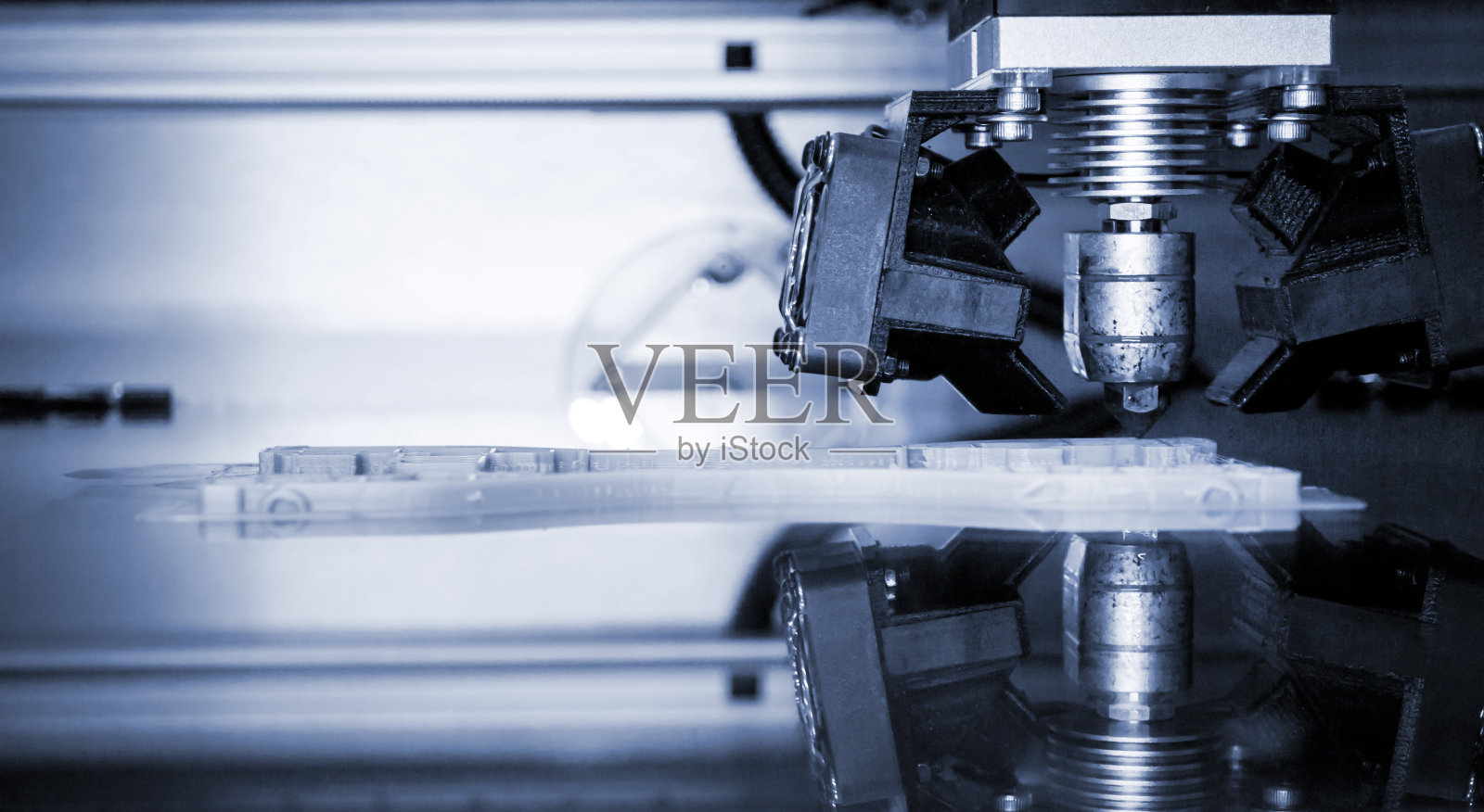 3D打印机打印孤立物体上的镜子反射表面特写。照片摄影图片