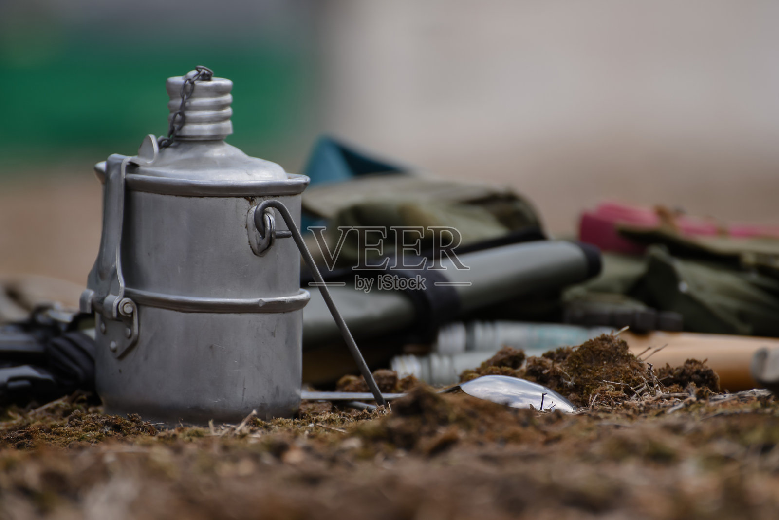 军用装备:靴子、圆顶礼帽、罐头食品、皮带和马克杯。大自然中的士兵午餐照片摄影图片