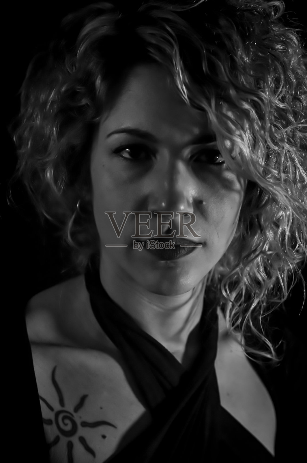 黑白肖像，一个美丽的卷发金发女人，正严肃地看着她的前面照片摄影图片