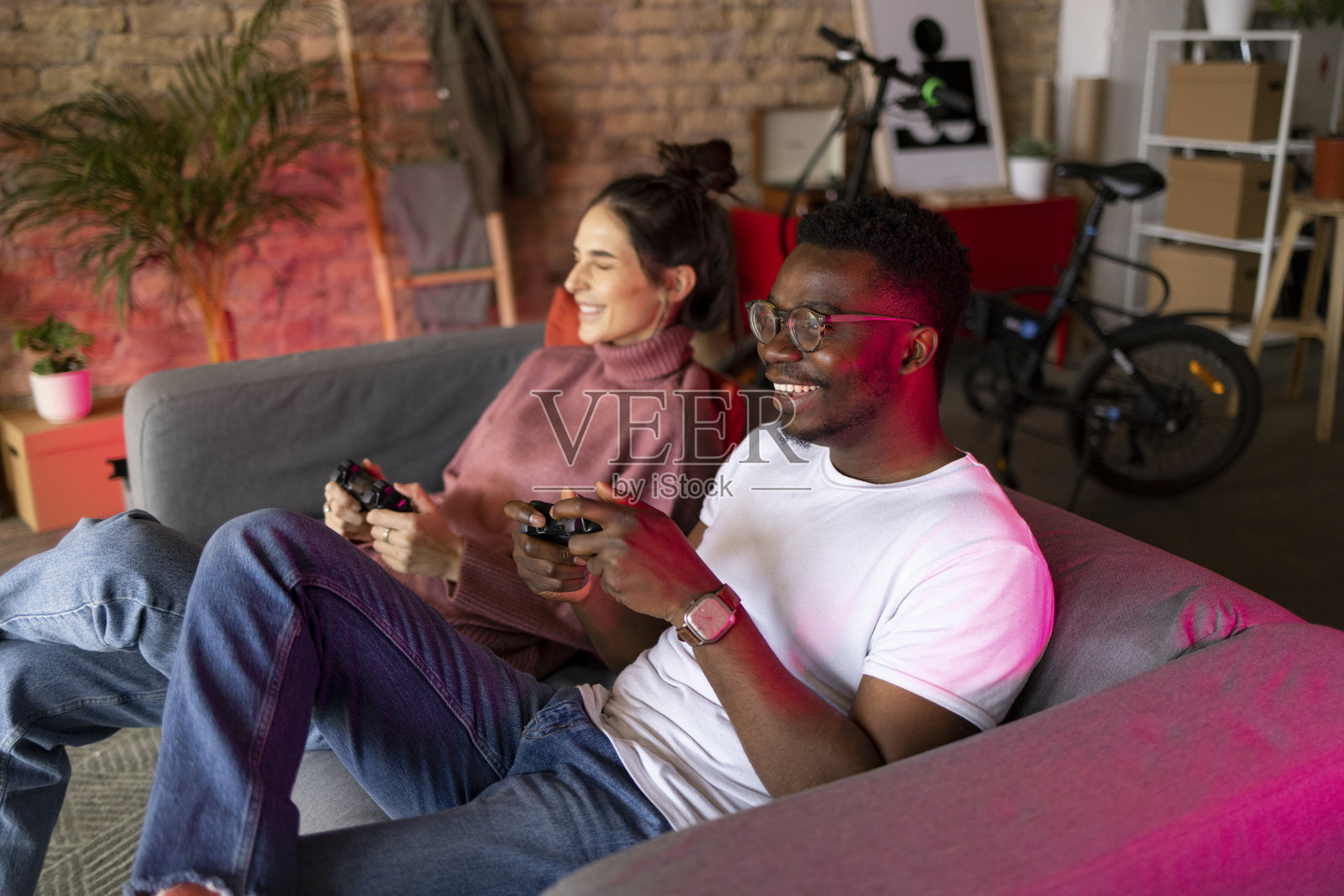 高角度侧视图不同的夫妇室友玩视频游戏在他们的公寓照片摄影图片