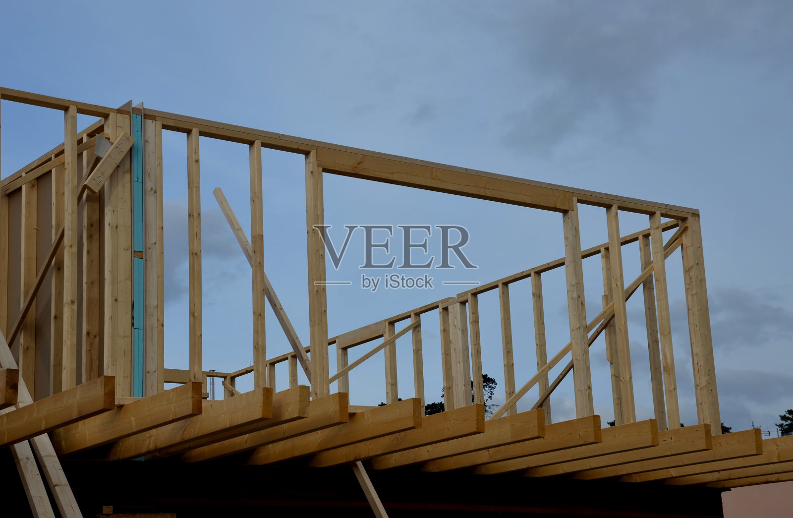 住宅的扩建部分，带有平屋顶、大窗户和露台的现代立方体。木制框架上将绝缘和包层。生态房屋可再生照片摄影图片