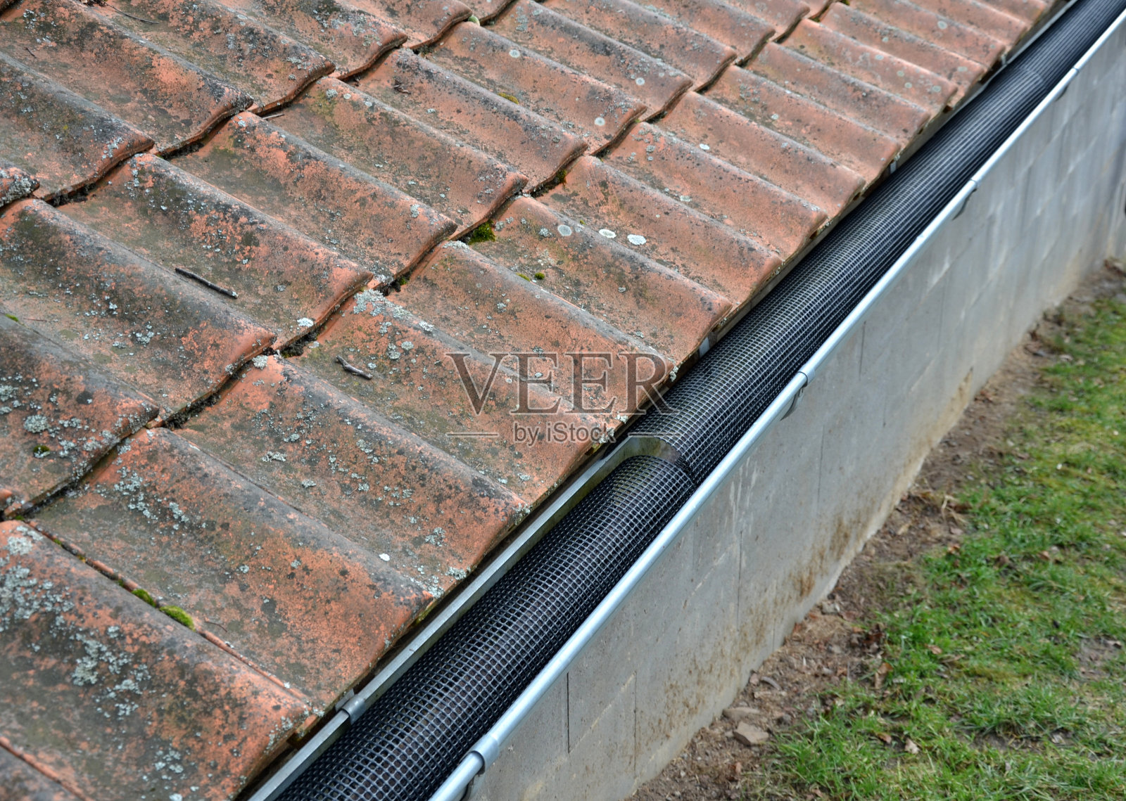 设计良好，用塑料网格覆盖排水沟内部。树的叶子不会落在里面。下水道堵塞已经成为过去。发射的瓦片照片摄影图片