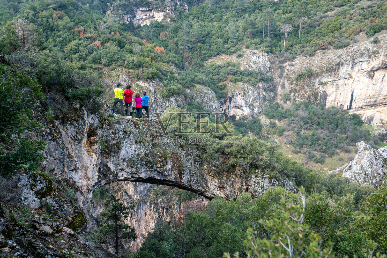 登山队伍站在岩石拱门在峡谷，看着美丽的风景，森林，峡谷照片摄影图片