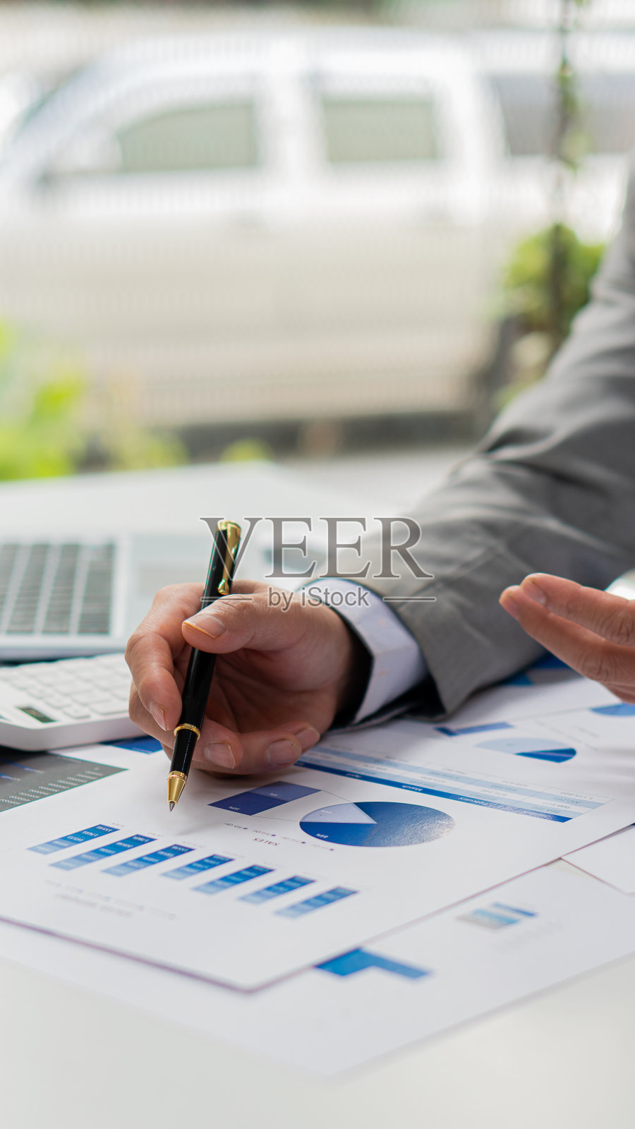 会计使用计算器和计算机，同时坚持企业会计的概念。预算和贷款手的人赚钱和计算费用在办公室垂直的图片照片摄影图片