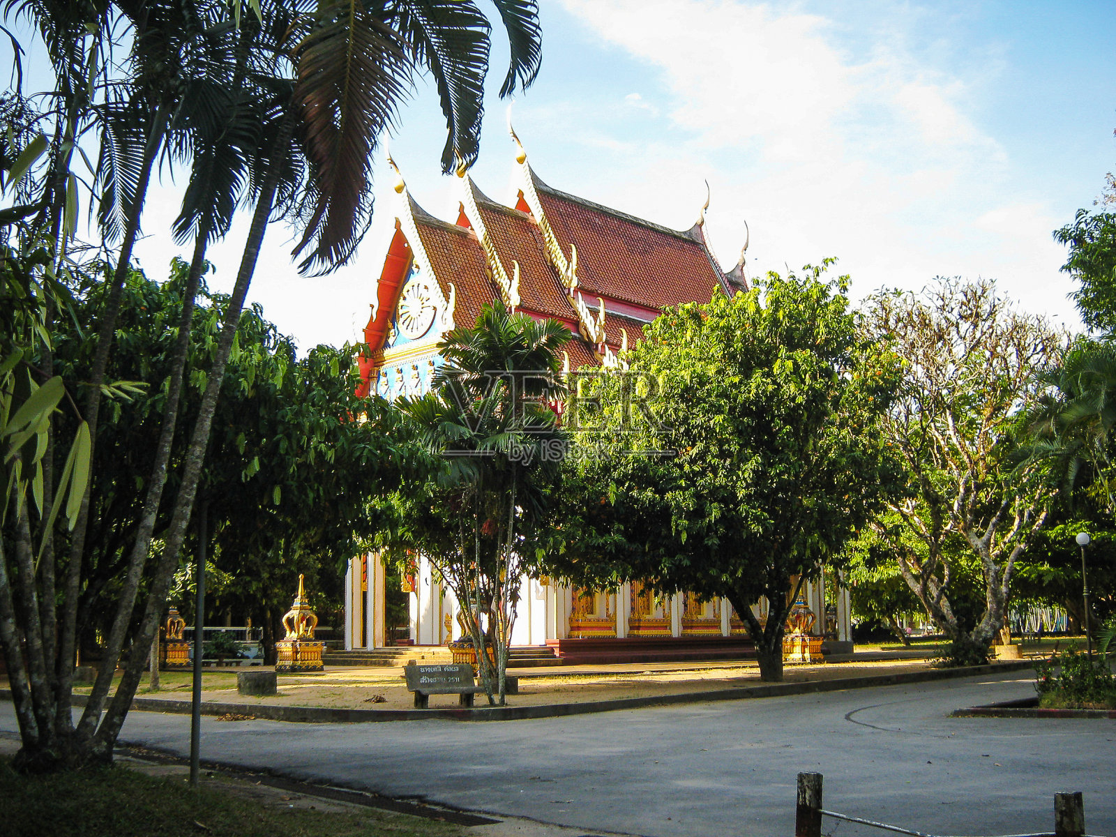 亚洲风格建筑的红色屋顶隐藏在棕榈树之间。泰国照片摄影图片