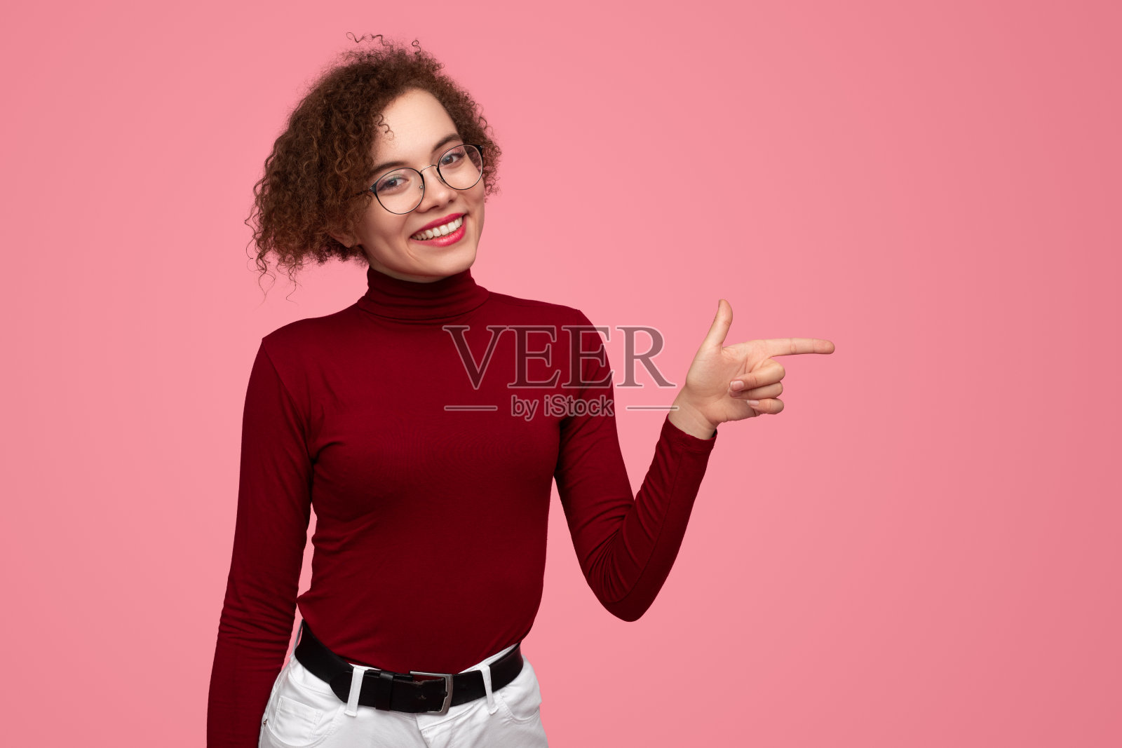 时尚的女人指着工作室照片摄影图片