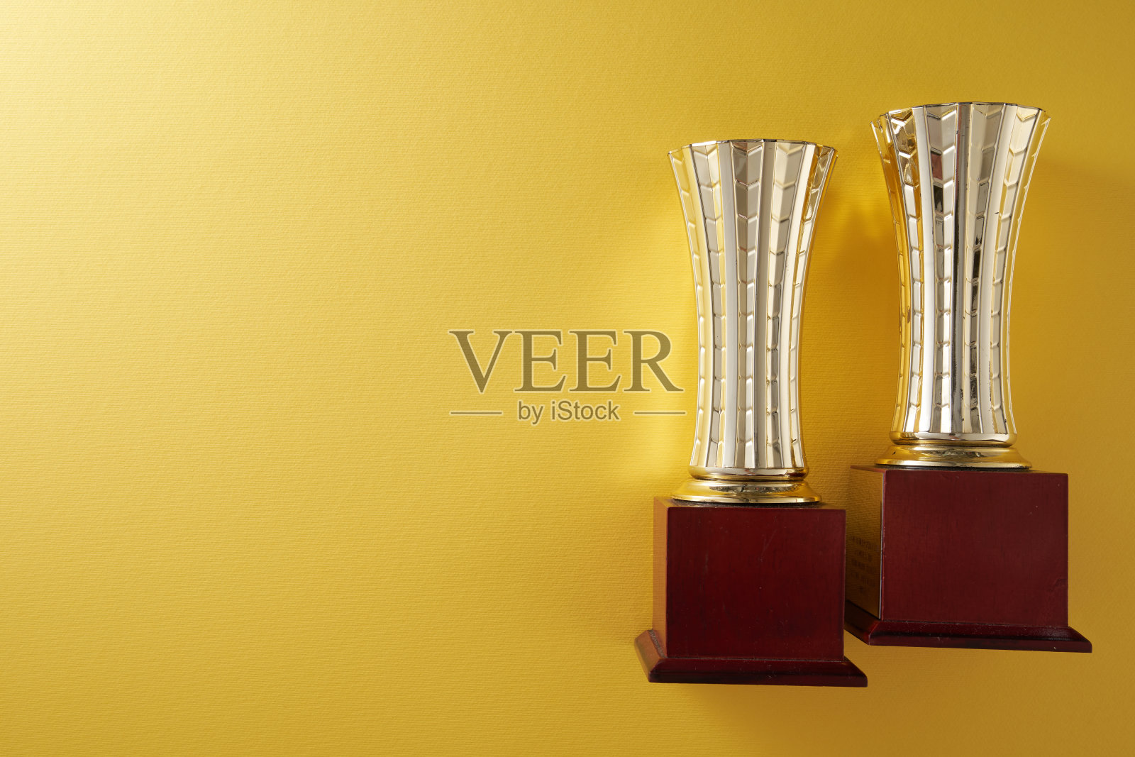 黄色背景下的金色奖杯照片摄影图片
