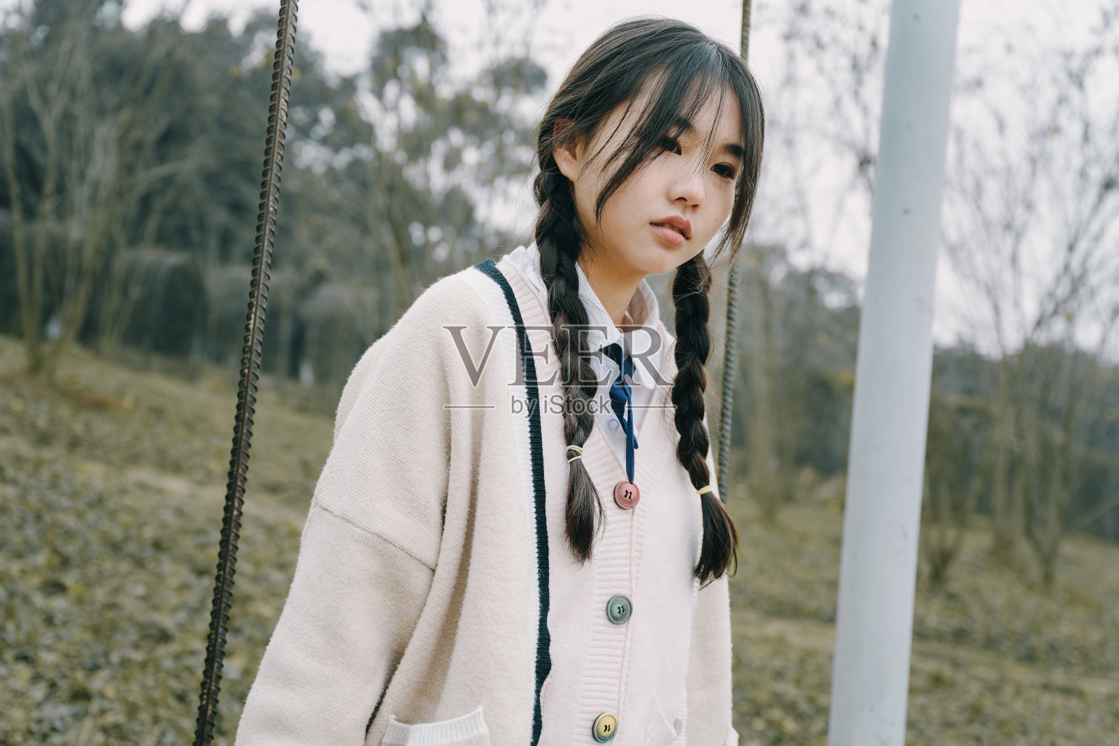 美丽的亚洲女孩在秋千上愉快地玩耍照片摄影图片