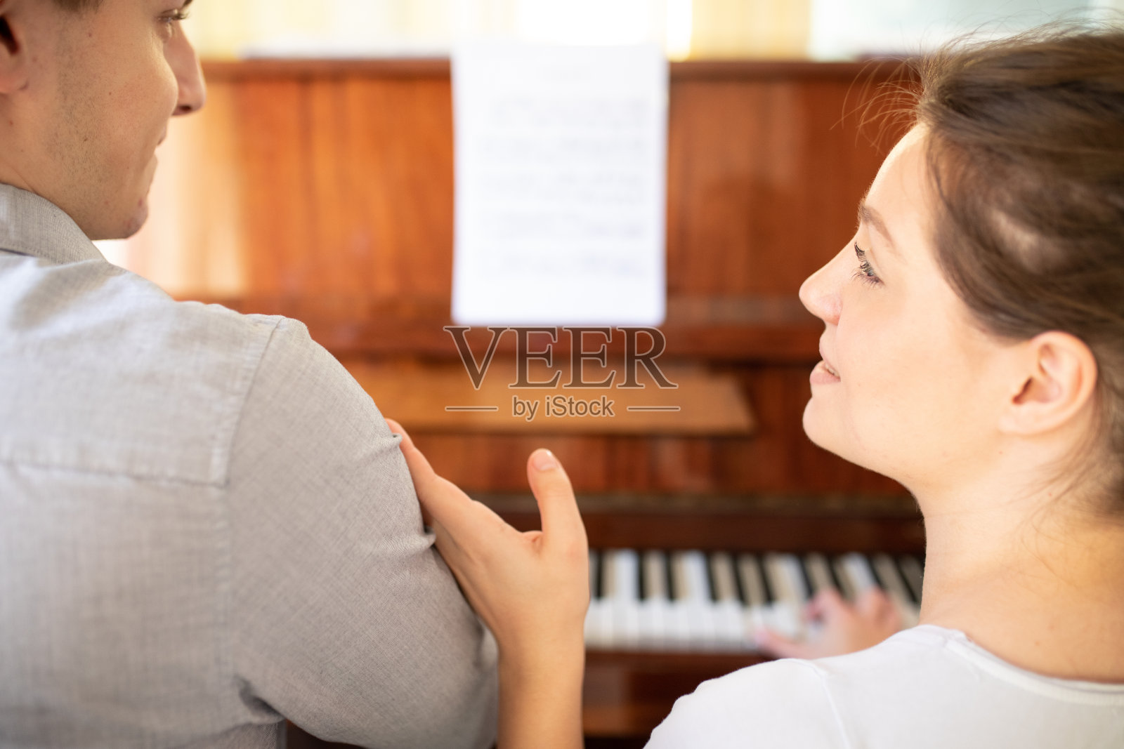哥哥教他妹妹弹钢琴照片摄影图片