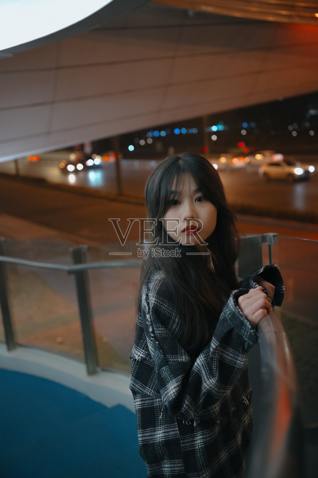 亚洲孤独的女孩靠在桥栏杆的夜晚照片摄影图片