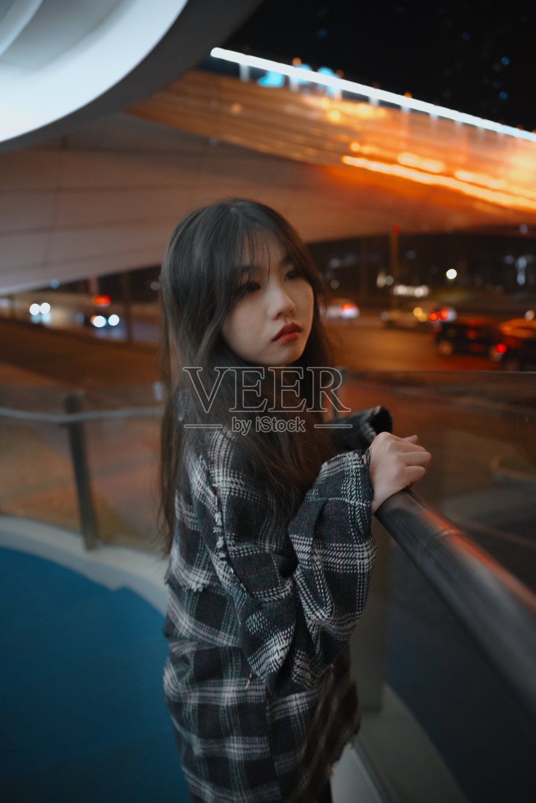 亚洲孤独的女孩靠在桥栏杆的夜晚照片摄影图片