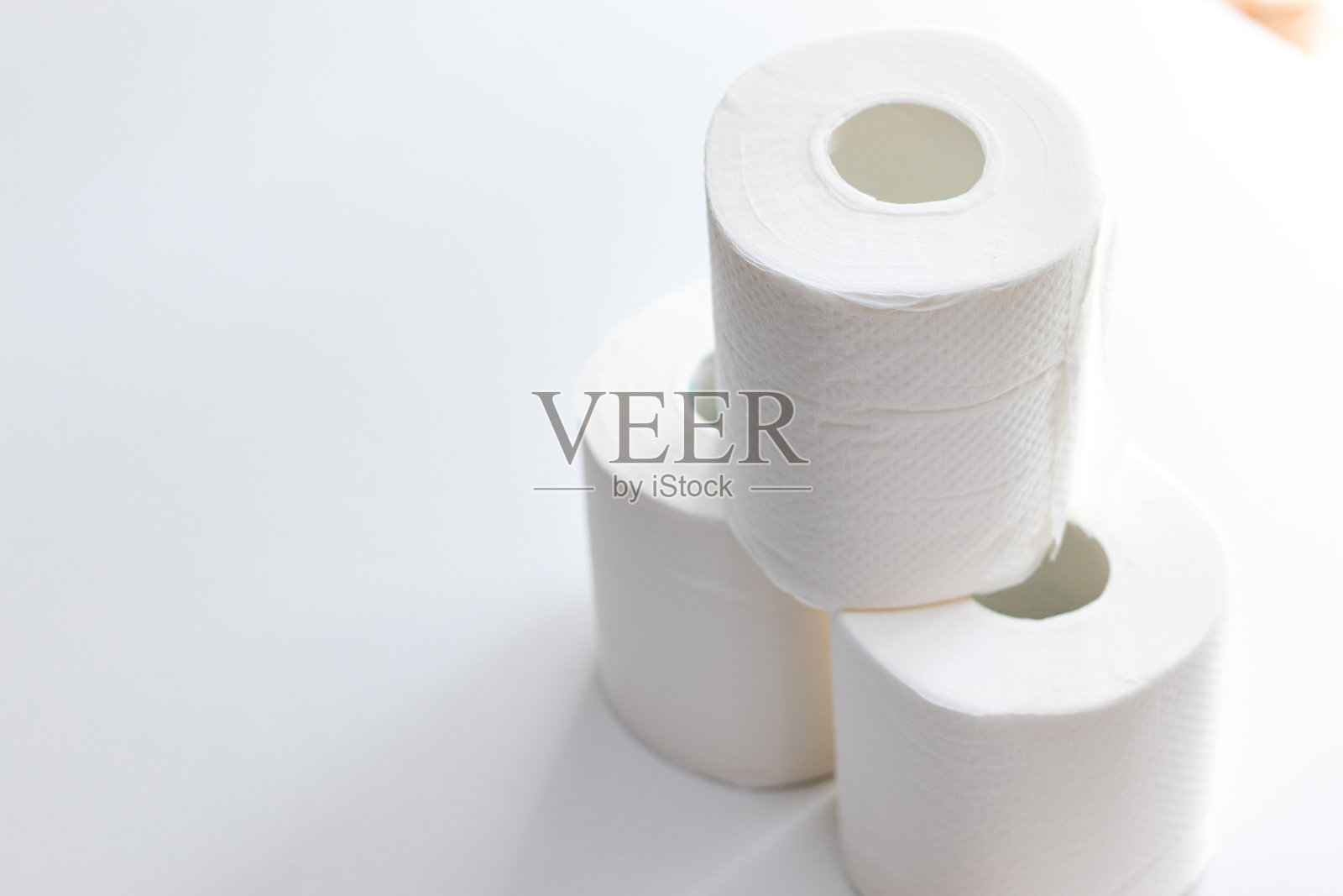 三卷卫生纸堆在白色的桌子上照片摄影图片