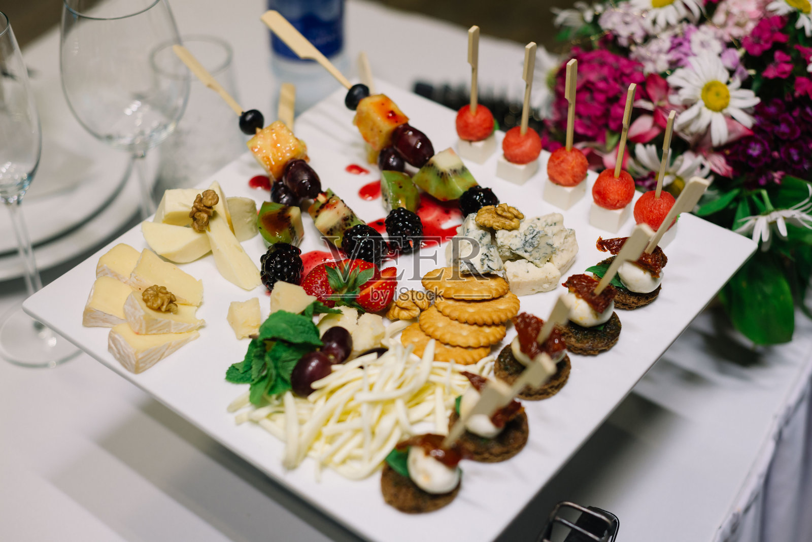 开胃菜在盘子里。餐饮服务。婚礼欢迎的食物。ncanape(虾、马苏里拉奶酪、晒干西红柿)。欢迎在活动中享用自助餐。照片摄影图片