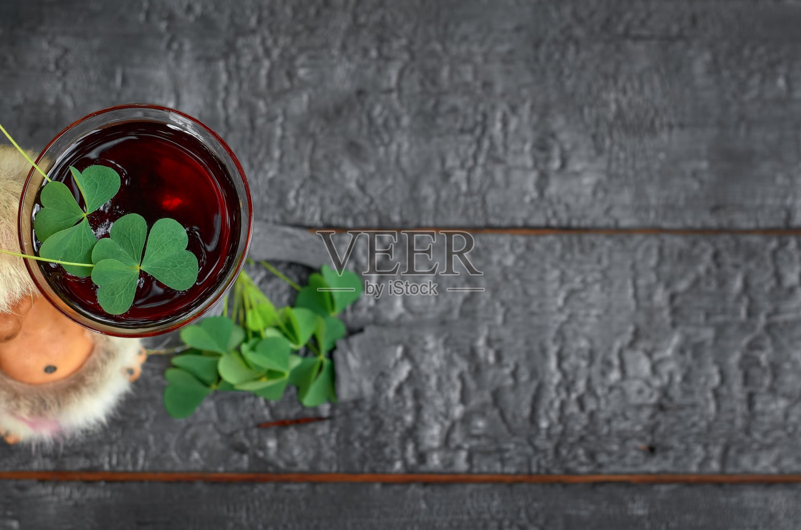 圣帕特里克节。三叶草，小鬼，一杯红酒在木制背景上照片摄影图片