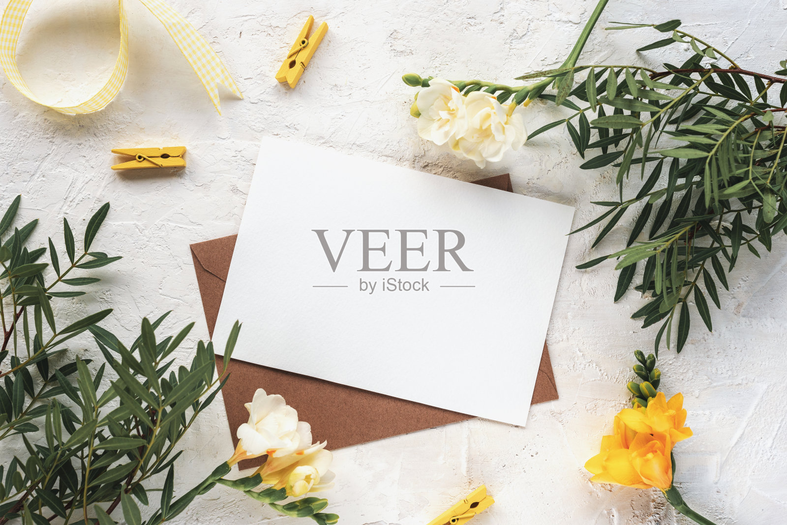 信封与空白纸在纹理背景与花和装饰。春天节日的概念。俯视图，平躺，模型照片摄影图片