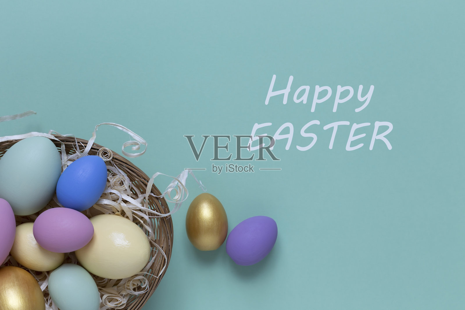 复活节背景与彩色鸡蛋在一个篮子在蓝色的背景。顶部视图与复制空间照片摄影图片