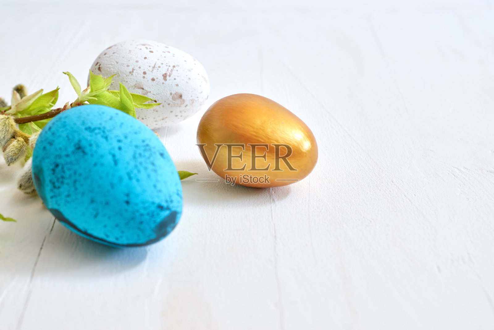 有嫩芽和绿叶的树枝，浅色背景上的复活节彩蛋。复活节快乐的概念与复制空间照片摄影图片