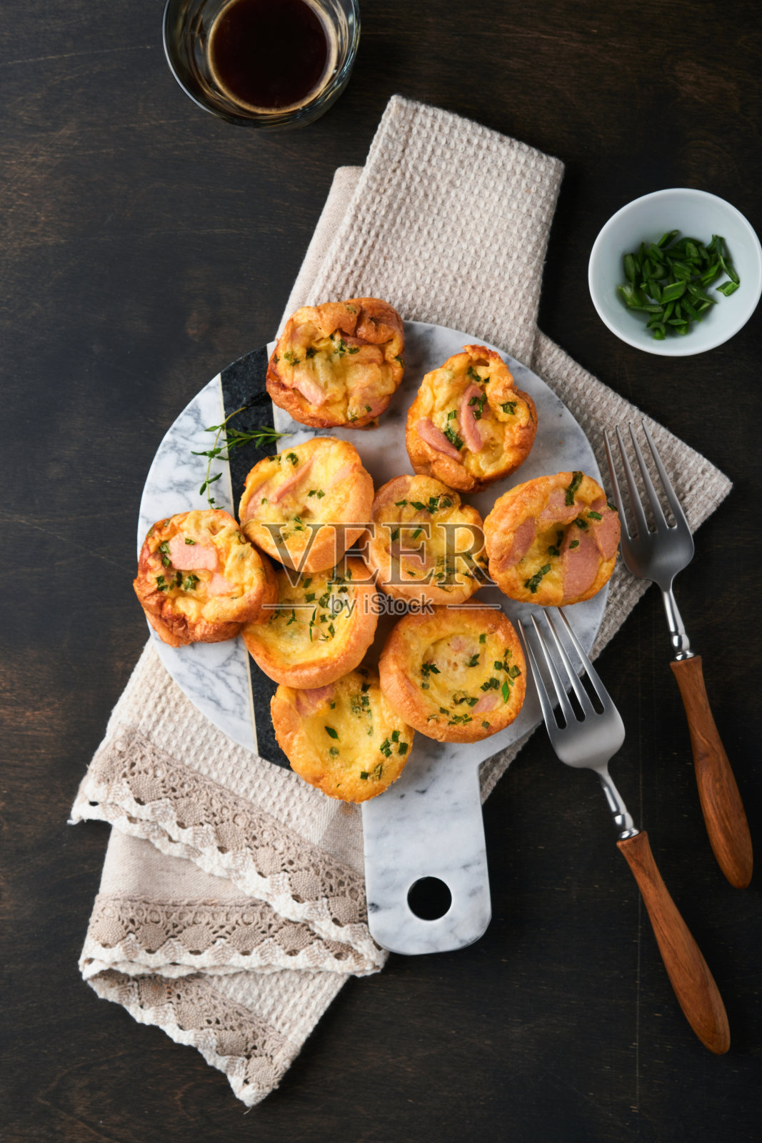 美味的鸡蛋松饼配青葱，培根，奶酪和西红柿，木板上古老的木制乡村背景。健康的高蛋白低碳水化合物早餐。自制的食物。照片摄影图片