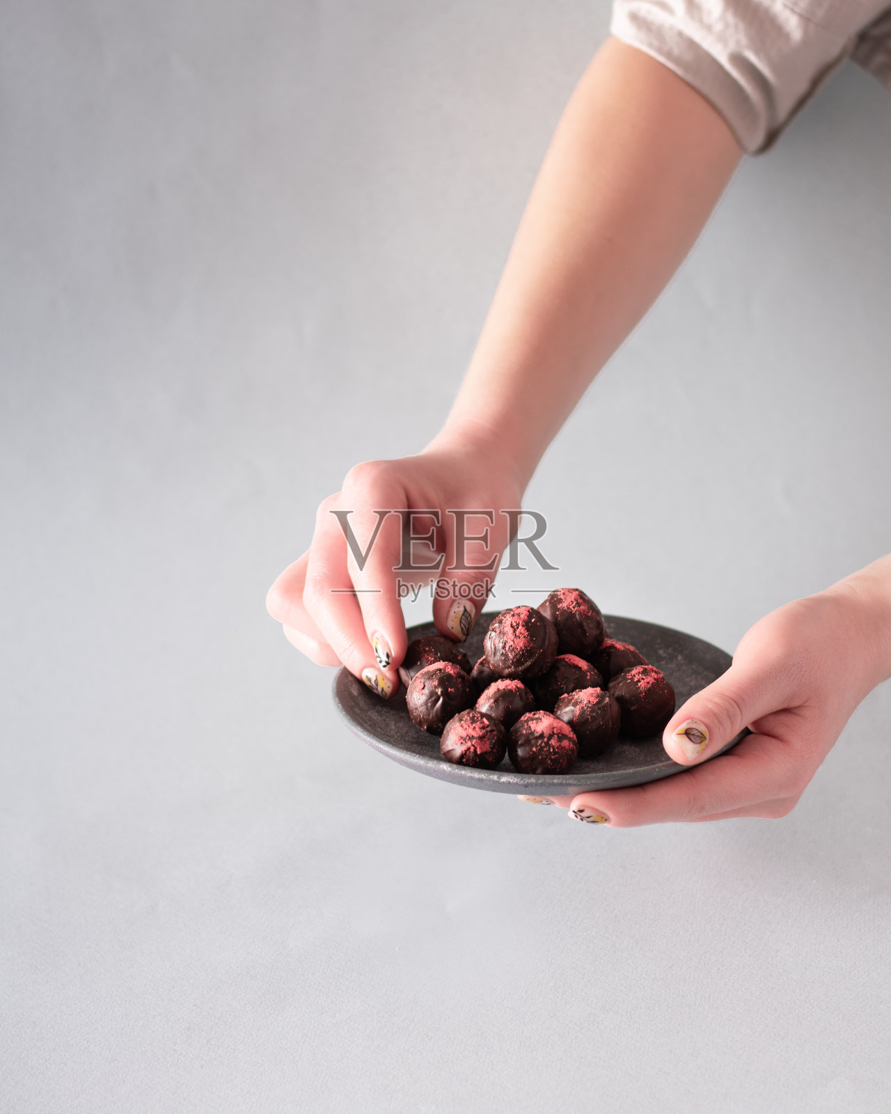 女手拿黑松露巧克力。垂直的。本空间照片摄影图片