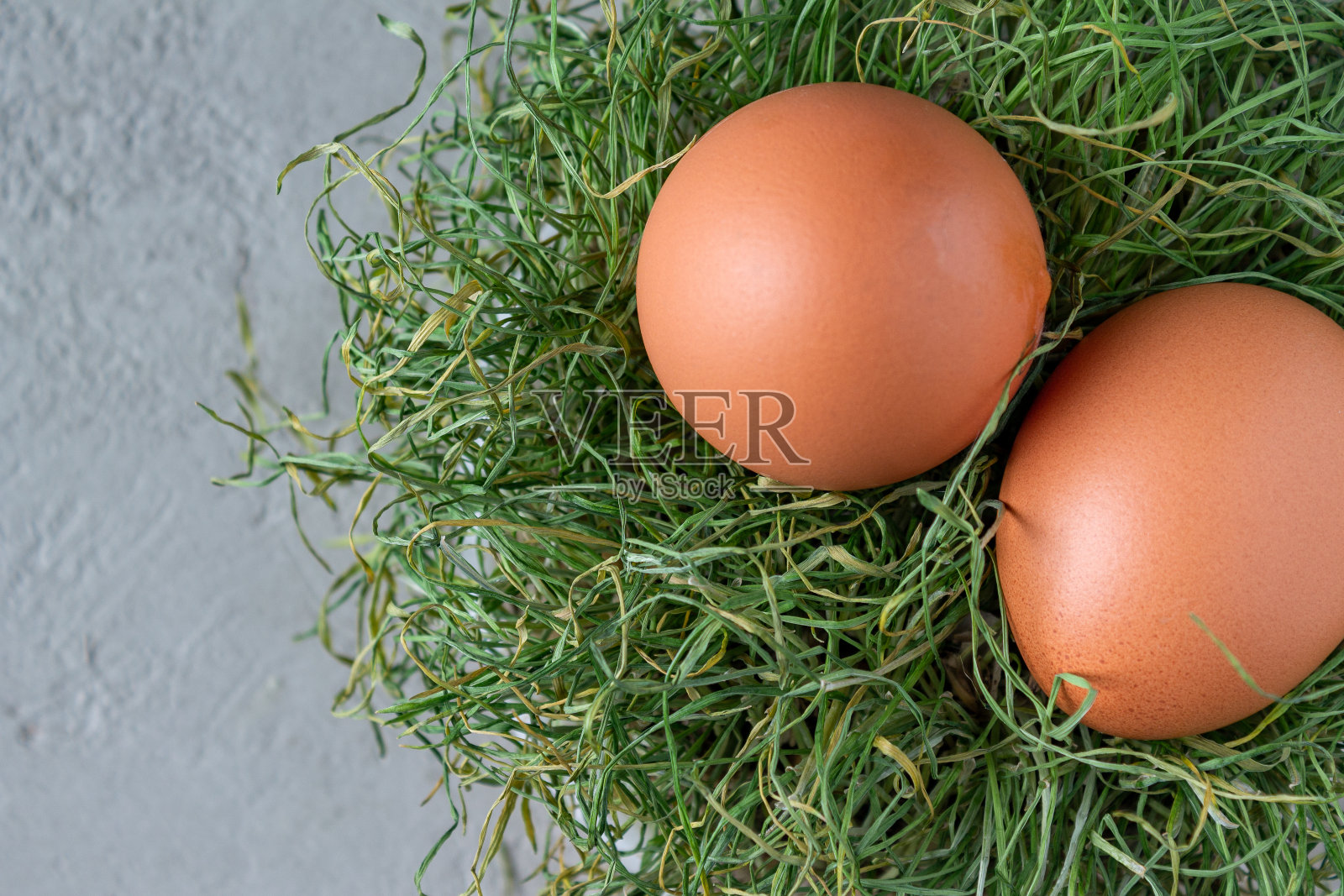 两个鸡蛋躺在干草窝里，特写镜头照片摄影图片